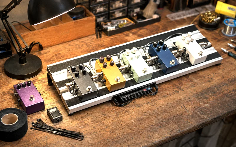 Organized guitar pedalboard with pedals mounted and cables routed cleanly