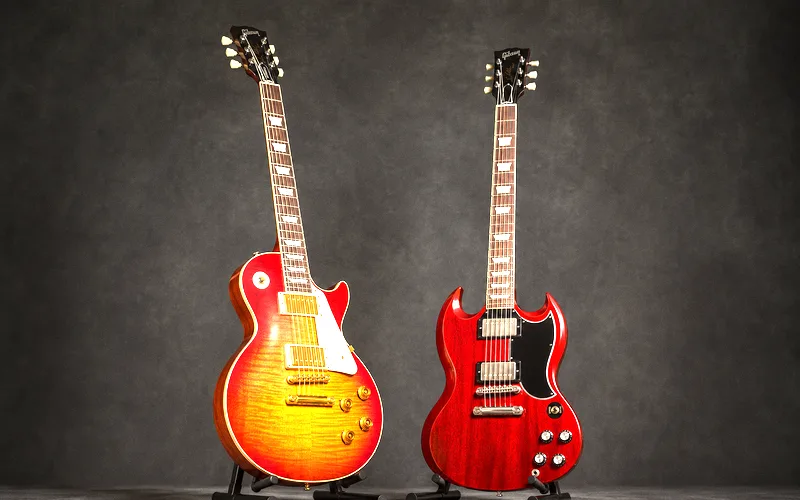 Gibson Les Paul with sunburst finish next to a cherry red Gibson SG showing the difference in body thickness and cutaway design
