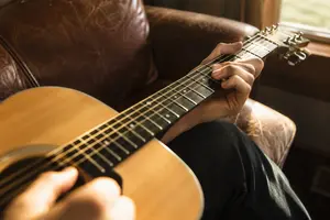 Beginner guitarist playing punk power chords on an electric guitar