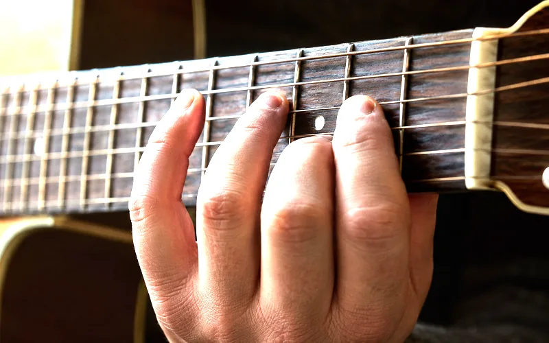 Close-up of a guitarist's left hand doing a chromatic warm-up exercise on the fretboard