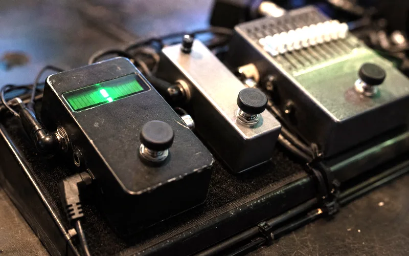 Essential guitar utility pedals including tuner, noise gate, and EQ on a pedalboard