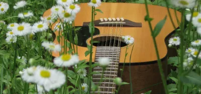 12 string acoustic guitar resting against an amp, ready for a beginner to play
