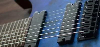 An 8 string guitar next to a standard 6 string guitar for comparison
