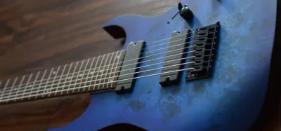 8 string guitar laid flat showing its extended fretboard and low strings