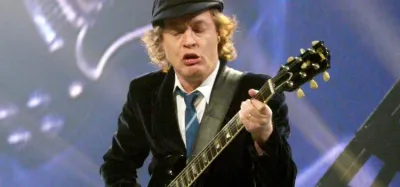 Angus Young of AC/DC playing his Gibson SG electric guitar on stage