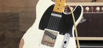 Electric guitar resting against a wall, illustrating the axe nickname