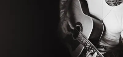 Acoustic guitar resting against an amp, ready for playing across music genres