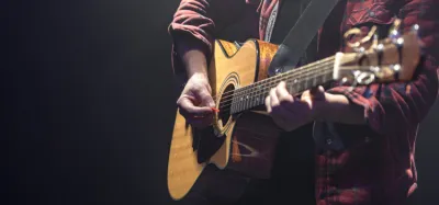 Acoustic guitar with a soundhole pickup being installed on a workbench