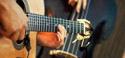 Acoustic guitarist playing, illustrating the levels of acoustic guitar playing