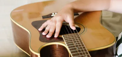Close-up of an acoustic guitar soundhole and strings showing where the sound is produced