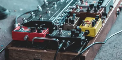 Distortion guitar pedal sitting on a pedalboard with cables connected