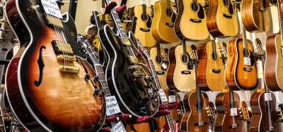 An electric guitar and an acoustic guitar side by side for a price comparison
