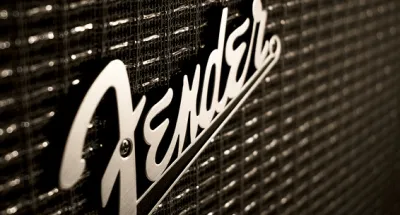 Fender distortion pedal on a pedalboard next to an electric guitar