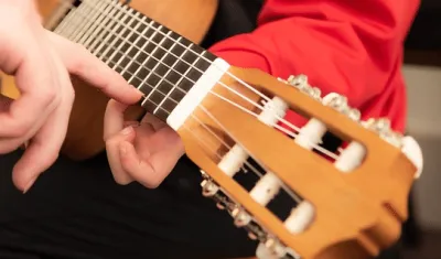 Student taking a guitar lesson with an instructor