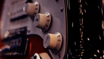 Guitar volume and tone potentiometers wired inside an electric guitar control cavity