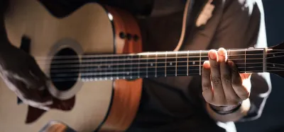 Acoustic-electric guitar with onboard preamp plugged in for a live performance