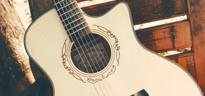 Acoustic-electric guitar leaning against an amp ready to plug in