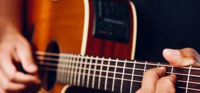 Acoustic-electric guitar with a cutaway body plugged into an amp