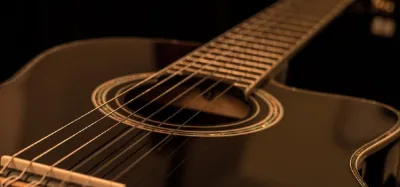 Intermediate player performing on an acoustic guitar