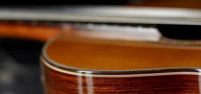 Player with small hands fretting a 3/4-size acoustic guitar