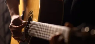 Acoustic guitar under $400 resting against a wooden chair
