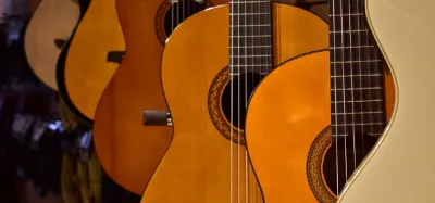 Classical nylon-string guitar resting against a chair, ready for a beginner to play