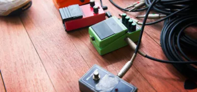 Compressor pedals lined up on a metal guitarist's pedalboard