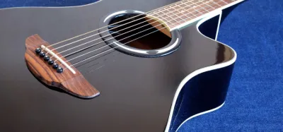 Cutaway acoustic guitar leaning against an amplifier on stage