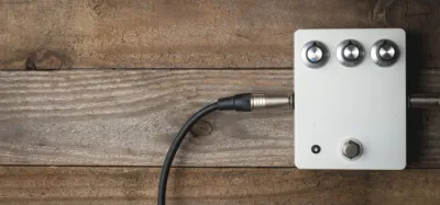 Compact delay pedals lined up on a guitar pedalboard