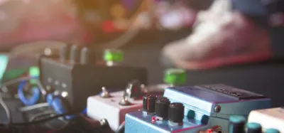 High-gain distortion pedals lined up on a metal guitarist's pedalboard