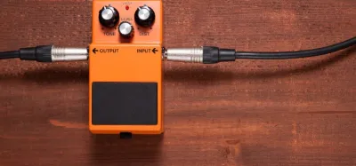 Distortion pedals lined up in front of a solid state guitar amp