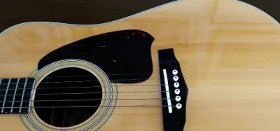 Fender acoustic guitar resting against an amp in a home studio