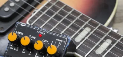 Fuzz pedal on a pedalboard paired with a humbucker-equipped electric guitar
