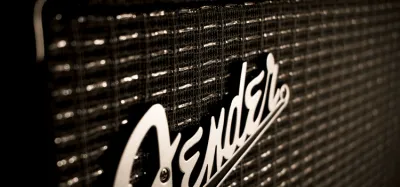 Guitar amplifier under $300 with glowing valve next to an electric guitar