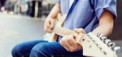 Lightweight electric guitar resting on a stand ready to play