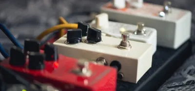 Mini reverb pedals lined up on a guitar pedalboard
