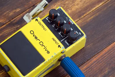 Overdrive pedal on a pedalboard in front of a Marshall guitar amp