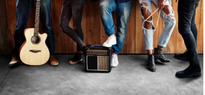 Small tube guitar amp glowing on a stage with a guitar leaning against it