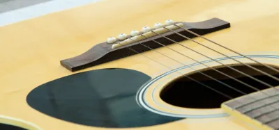 Taylor acoustic guitar leaning against an amp, ready to play