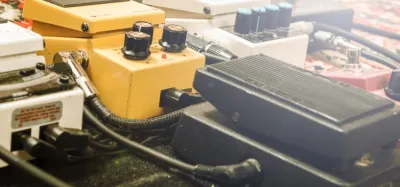 Tube distortion pedal with a glowing vacuum tube on a pedalboard