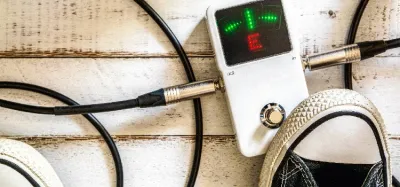 Guitar tuner pedal on a pedalboard showing in-tune status