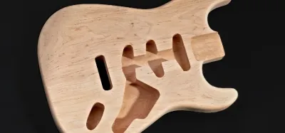 Electric guitar bodies showing different tonewoods including mahogany, ash, and maple
