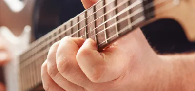 Close-up of an electric guitar neck showing the wood grain