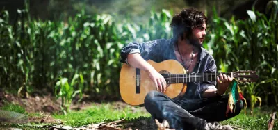 Acoustic guitar being played around a campfire at night