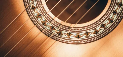 A nylon-string classical guitar next to a steel-string acoustic guitar for comparison