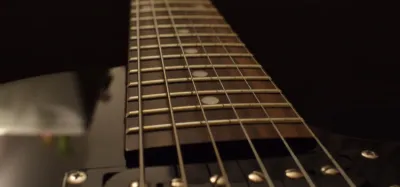 Cleaning guitar strings with a microfiber cloth on an acoustic guitar