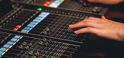 A laptop running a digital audio workstation next to a guitar loop pedal