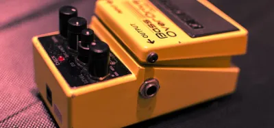 Distortion pedal on a pedalboard connected to a guitar amplifier preamp