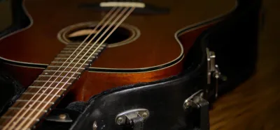 A large dreadnought acoustic guitar next to a smaller concert-sized acoustic guitar for comparison