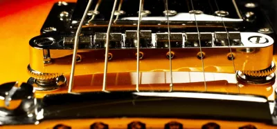 Close-up of an electric guitar bridge showing strings and saddles